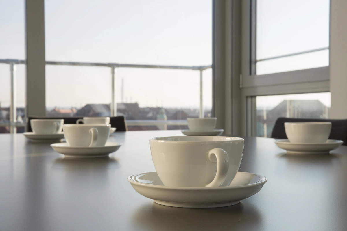 Cup of coffee on a table with a view outside.
